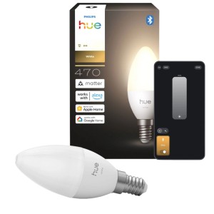 Philips Hue E14 LED-Leuchtmittel Kerzenform, warmweiß leuchtend, daneben Verpackung und Smartphone mit App.