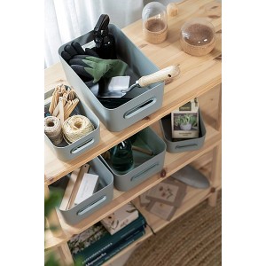 SmartStore Aufbewahrungskörbe Comfort M in Aquaverde auf Holzregal mit Gartenzubehör.