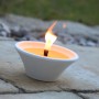 Citronella Kerze in weißer Terracotta Schale mit brennender Flamme. Duftkerze für den Außenbereich.