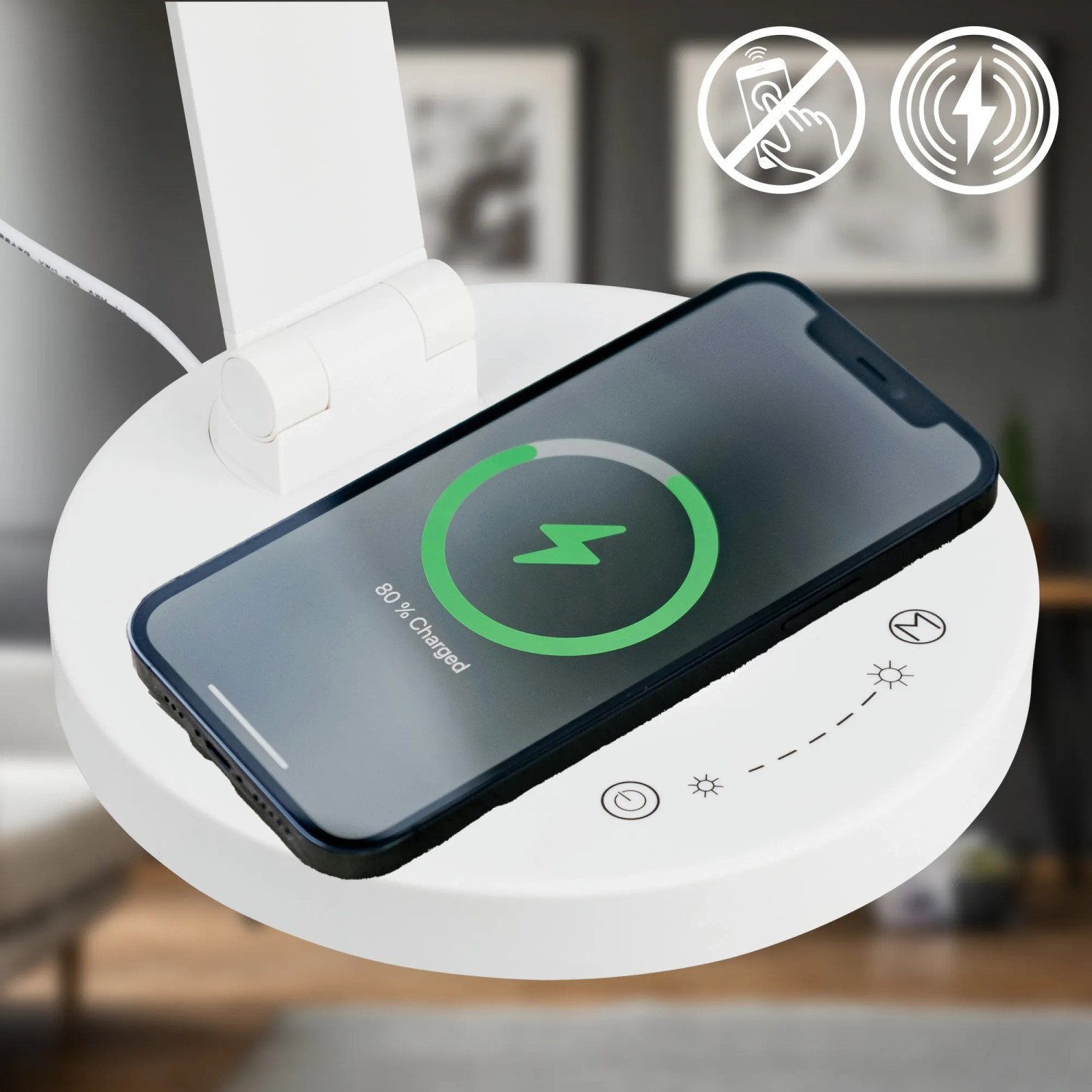 Weiße Brilo LED-Tischleuchte Cuma mit induktiver Ladestation und Smartphone.