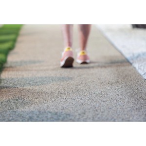 Nahaufnahme der Heissner Steinfolie (40x250cm) als Gehweg mit Person im Hintergrund.