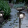 LED-Solar-Spot Travi als Wegeleuchte im Garten, mit Erdspieß und Solarpanel.