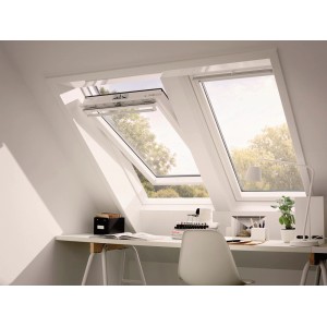 VELUX Schwingfenster F04 aus Kunststoff, geöffnet in Dachschräge über Schreibtisch.