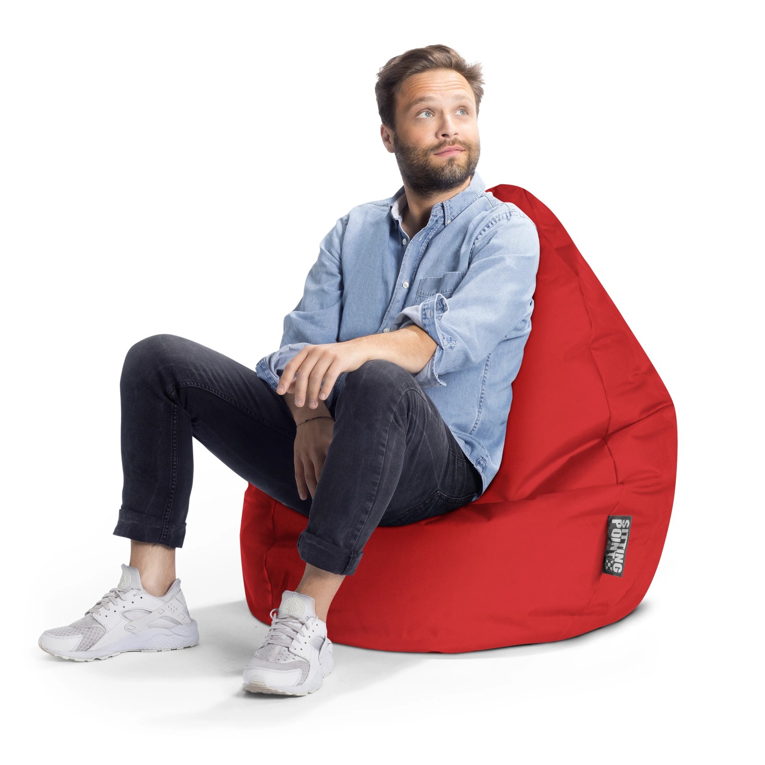 Mann sitzt entspannt auf rotem Sitting Point Sitzsack Brava 120l. Bequemer Sitzsack für Kinderzimmer.