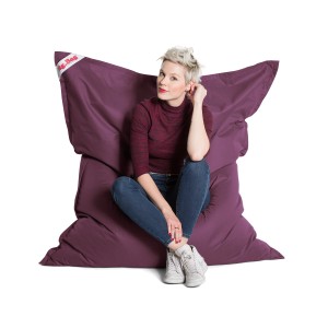 Frau sitzt auf großem, auberginefarbenem Sitting Point Sitzsack Big Bag Brava.