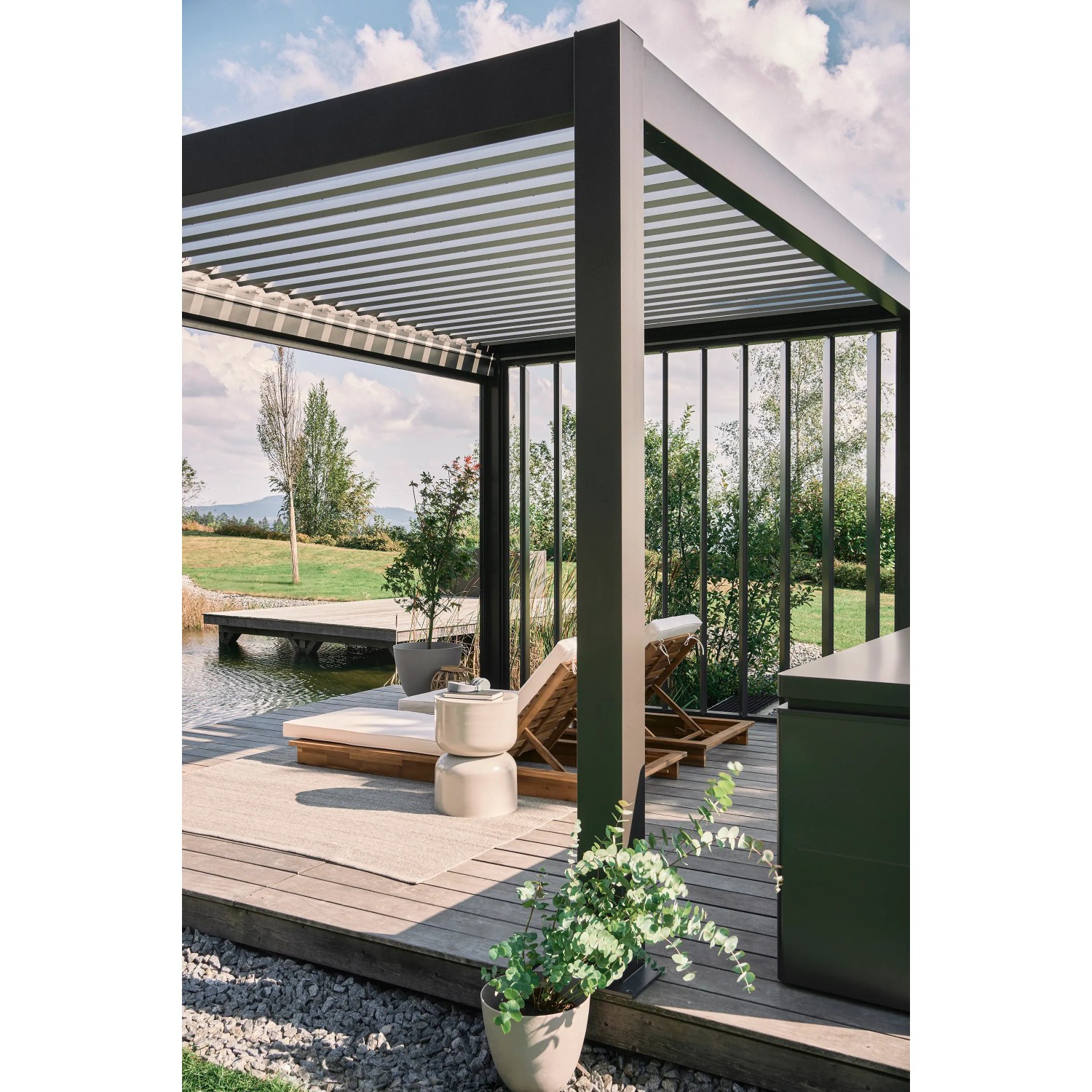 Biohort Pergola in Dunkelgrau/Silber-Metallic mit Lamellendach und Lounge-Bereich im Garten.