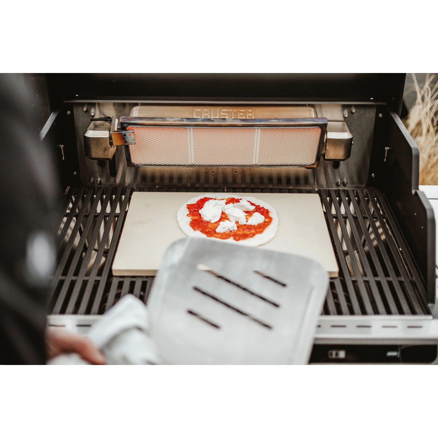 Enders Pizzastein eckig (40x30 cm) auf Grill mit Pizza belegt.