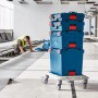 Gestapelte blaue Bosch Professional L-Boxx Werkzeugkoffer auf Rollbrett im Rohbau.