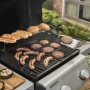 Weber Gasgrill E-210 Spirit 2025 in Schwarz mit Würstchen, Burger und Brötchen auf dem Grill.