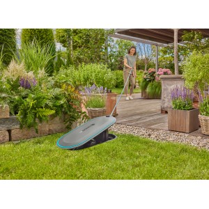 Gardena Undercover Schlauchbox RollUp M 20 m im Garten, mit Frau und Schlauch. Schlauchwagen für Bewässerung.