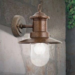 Vintage-braune Außenwandleuchte aus patiniertem Stahl mit klarem Glasschirm, montiert an einer Steinwand.