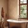 Beige Vliestapete in Marmor-Stein-Optik von Marburg im Badezimmer mit Badewanne und Fenster.
