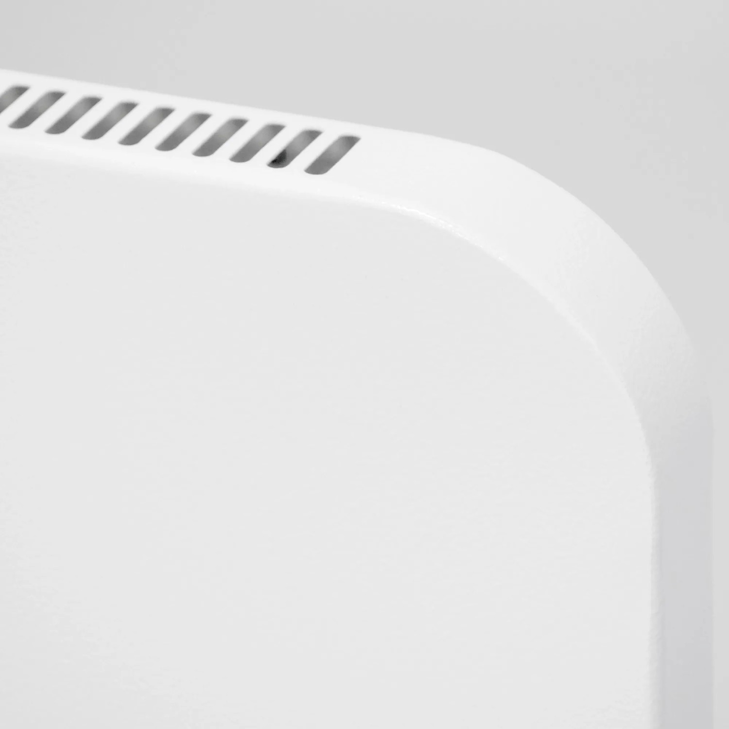 Detailaufnahme: Weiße Vasner Konvi Plus Hybridheizung, abgerundete Ecke mit Lüftungsschlitzen.