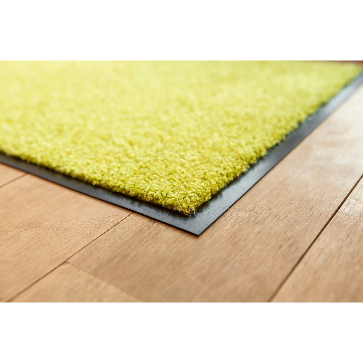 Grüne Astra Sauberlaufmatte Proper Tex Uni, 60x180 cm, auf Holzboden.