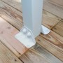 Detailaufnahme der weißen Palram Olympia Terrassenüberdachung Befestigung auf Holzterrasse.