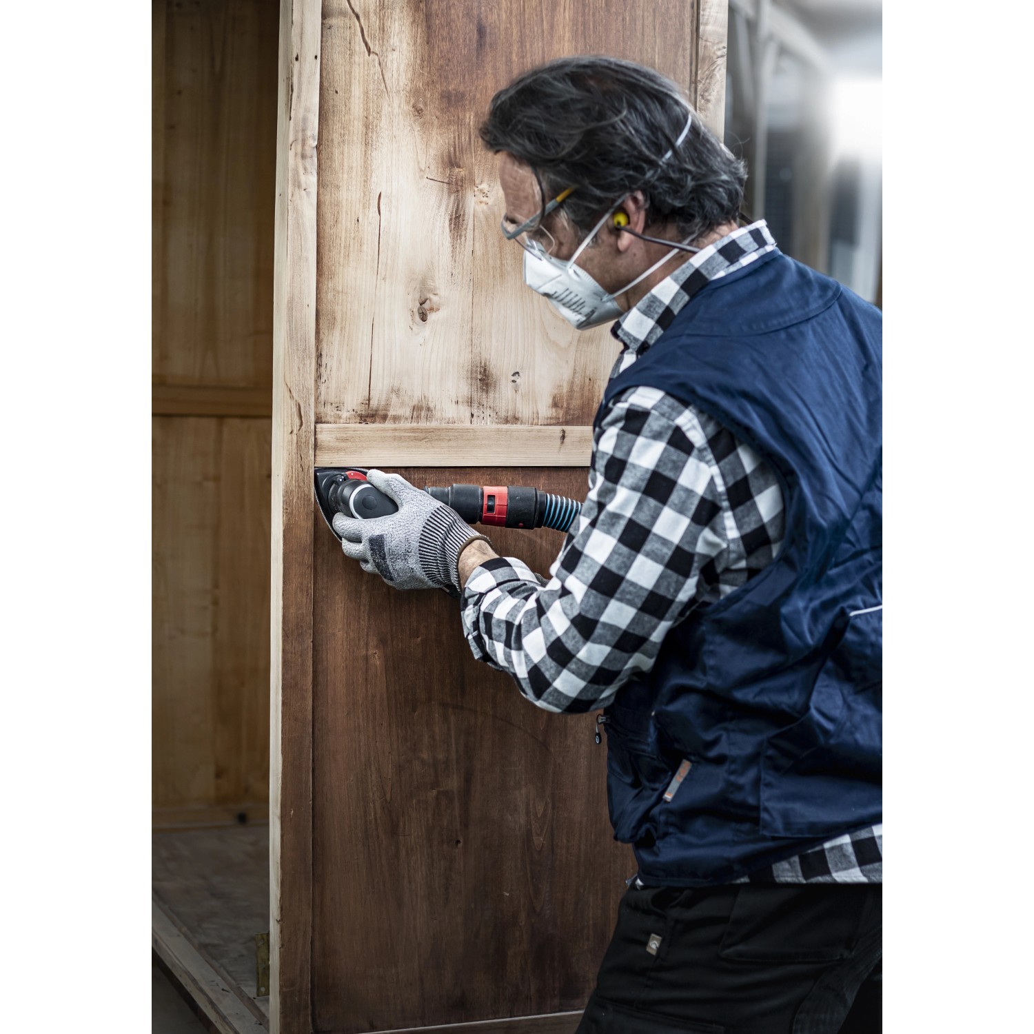 Mann schleift Holz mit Deltaschleifer und Bosch Expert Schleifblatt C470 K100.