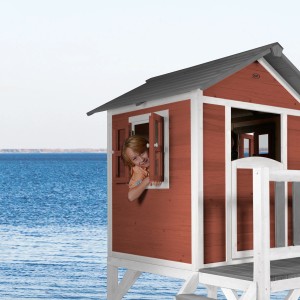 Axi Spielhaus Lodge XL in skandinavischem Rot mit Rutsche, Kind schaut aus Fenster.