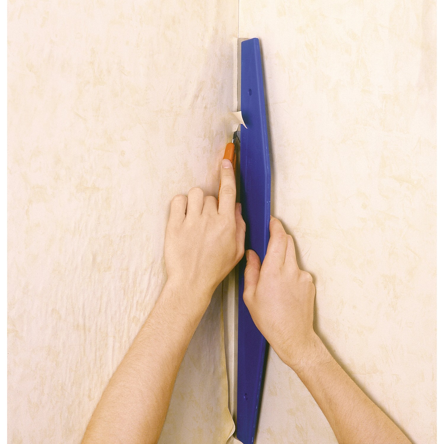 LUX Beschneidelineal 60 cm im Einsatz: Tapete wird mit Messer zugeschnitten.