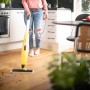 Frau reinigt Holzboden mit gelbem Kärcher Dampfreiniger SC 3 Upright EasyFix.