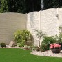 Beige Betonzaun-Bogenplatte Montana (200x45x3 cm) als Sichtschutz im Garten.