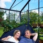 Juliana Gewächshaus Orangerie 15: Paar entspannt in Hängematte im Gewächshaus mit schwarzem Rahmen.