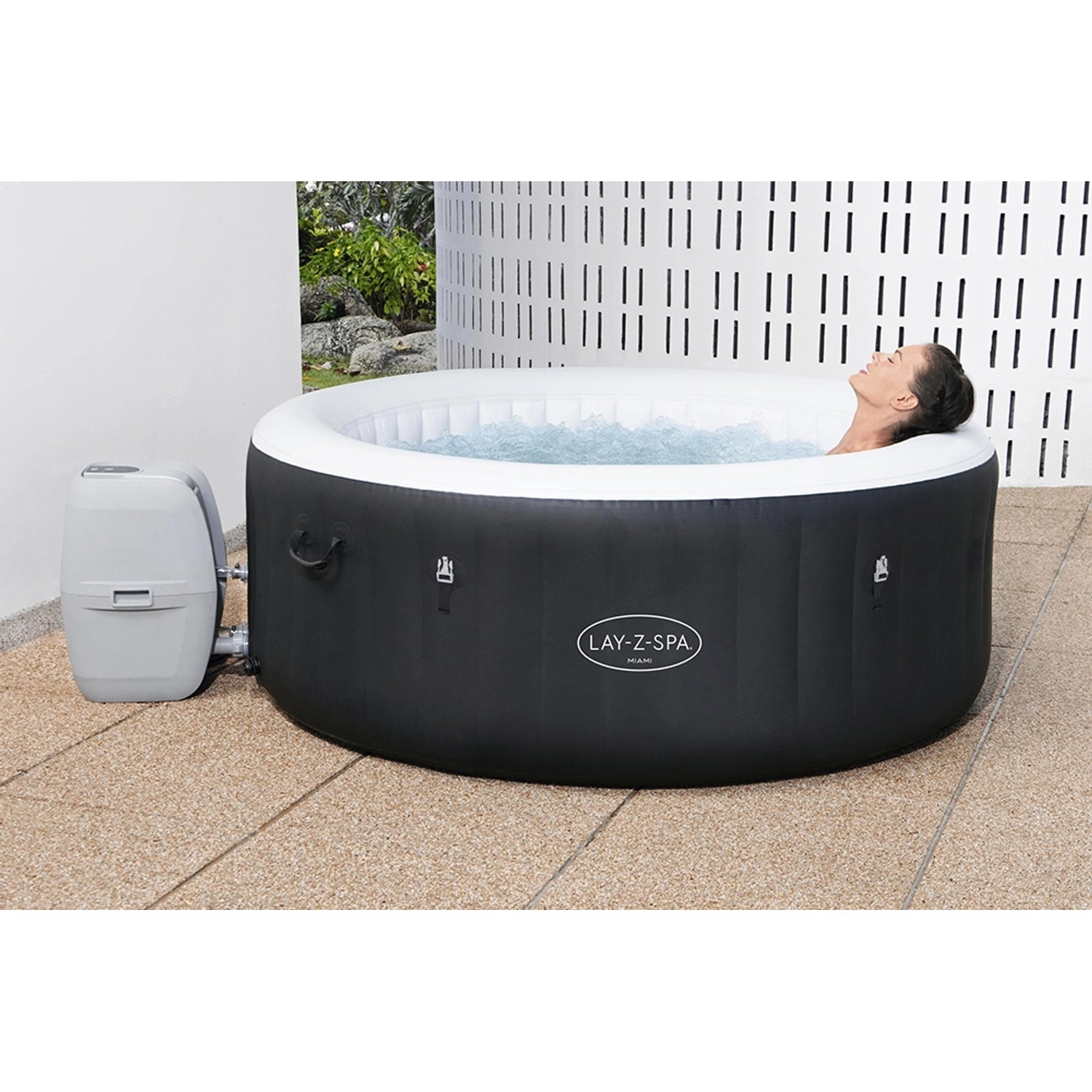 Bestway Lay-Z-Spa Miami AirJet: Aufblasbarer, runder Whirlpool in Schwarz mit Filterpumpe und entspannender Person.