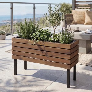 Brauner MCW Pflanzkasten P84 aus Stahl und Akazie, 36x62x22cm, mit Pflanzen auf einer Terrasse.