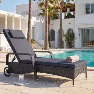 Anthrazitfarbene Poly-Rattan Sonnenliege „Cesena“ mit grauen Kissen am Pool.