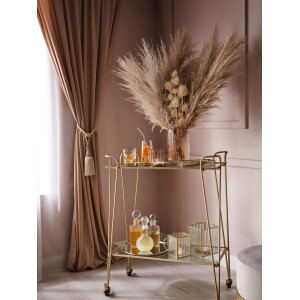 Goldfarbene Laterne Modern Antique auf Barwagen mit Deko-Elementen wie Pampasgras und Karaffen.