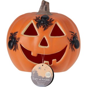 Oranger Halloween-Kürbis mit leuchtendem Gesicht und drei schwarzen Spinnen. Dekorative Figur mit Licht.