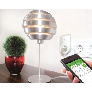 WLAN Steckdose in Weiß mit Lampe und Smartphone-Steuerung im Wohnraum.