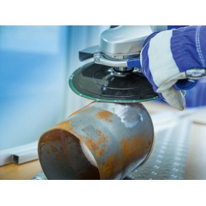 LUX Fiberscheibe im Einsatz: Winkelschleifer beim Entrosten eines Metallrohrs.