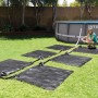 Intex Solarmatte 120x120 cm zur Poolwasser-Erwärmung im Garten mit Pool und Frau.