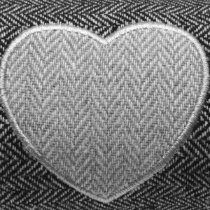 Detailansicht: Anthrazitfarbener Beautissu Zugluftstopper mit Herz-Applikation.
