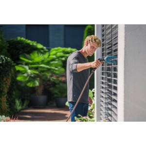 Mann reinigt Jalousien mit Gardena Cleansystem Jalousienbürste mit Wasseranschluss.