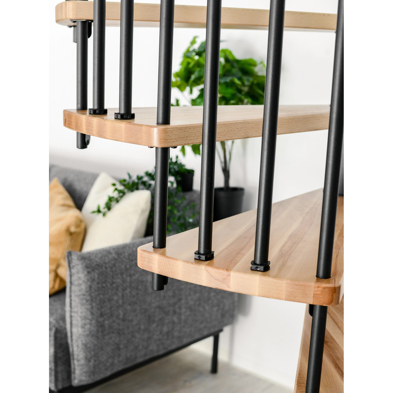 Detailaufnahme: Minka Spindeltreppe Spiral Wood Buche, schwarze Metallstäbe, helle Holzstufen.