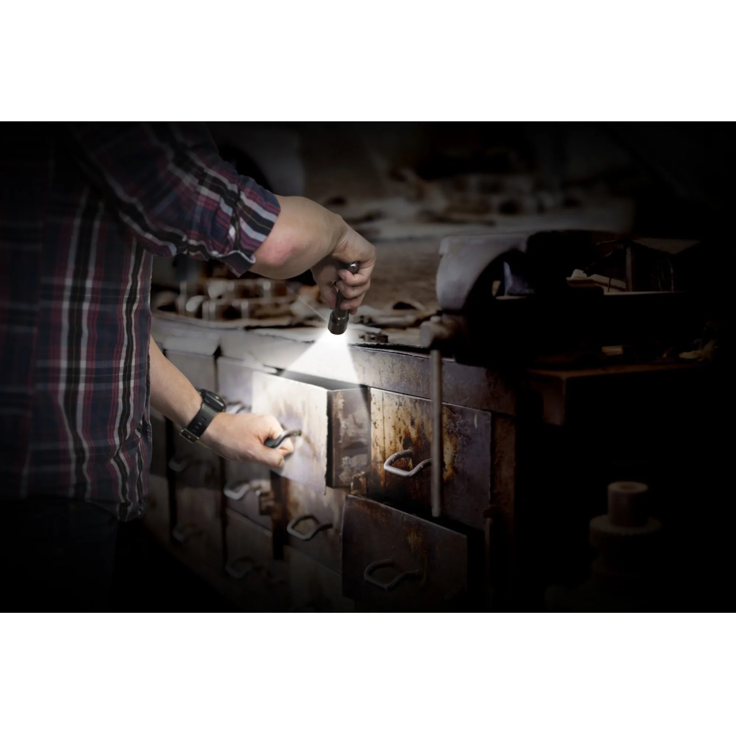 Mann nutzt Energizer Vision HD Metall Taschenlampe, um in einen dunklen Schrank zu leuchten.