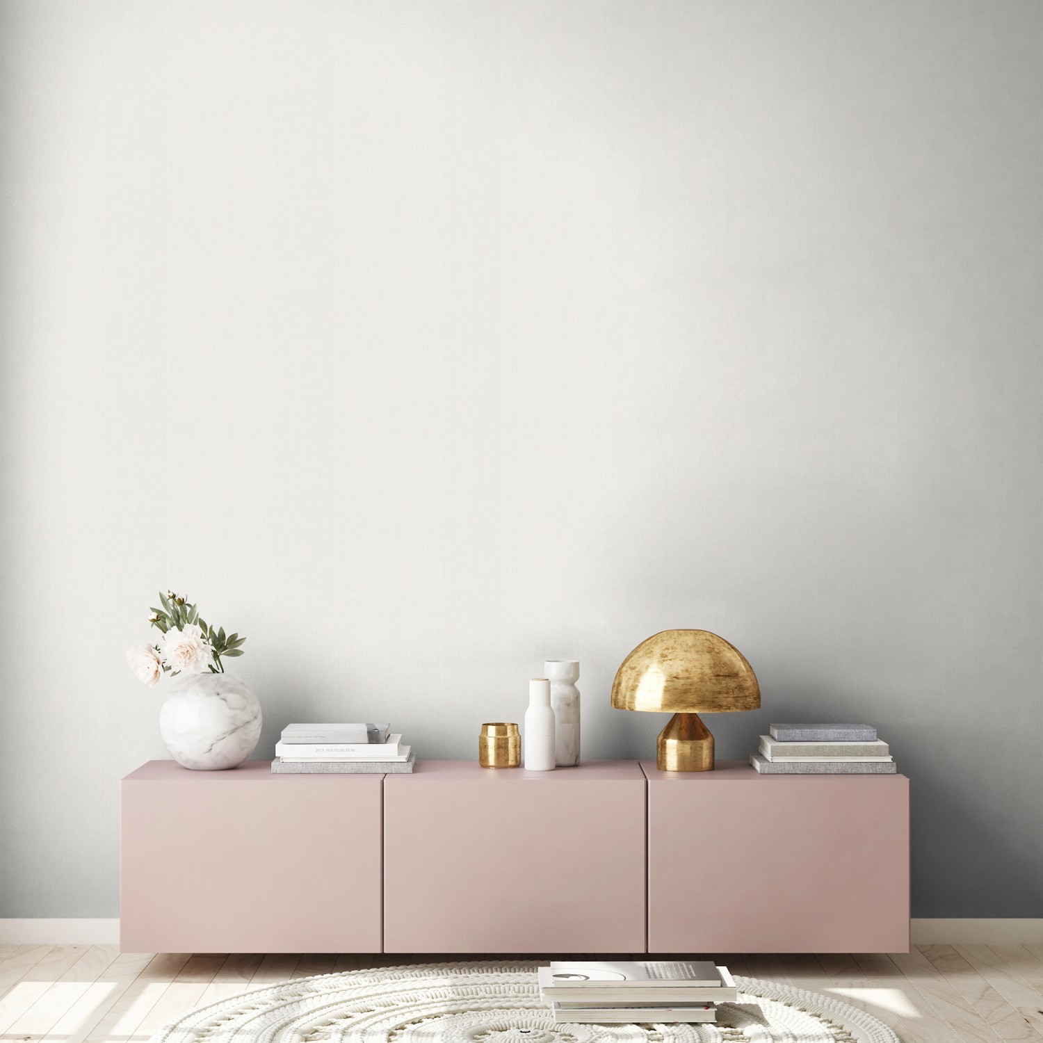 Wohnraum mit weißer Vliestapete Uni Metallic, rosa Sideboard und Deko.