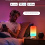 Govee RGBICWW LED-Tischlampe H6022 neben Nutzer im Schlafzimmer mit farbiger Beleuchtung.