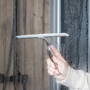 Hand wischt mit Schulte Glaswischer Chrom eine Duschwand ab. Zubehör zur Badreinigung.