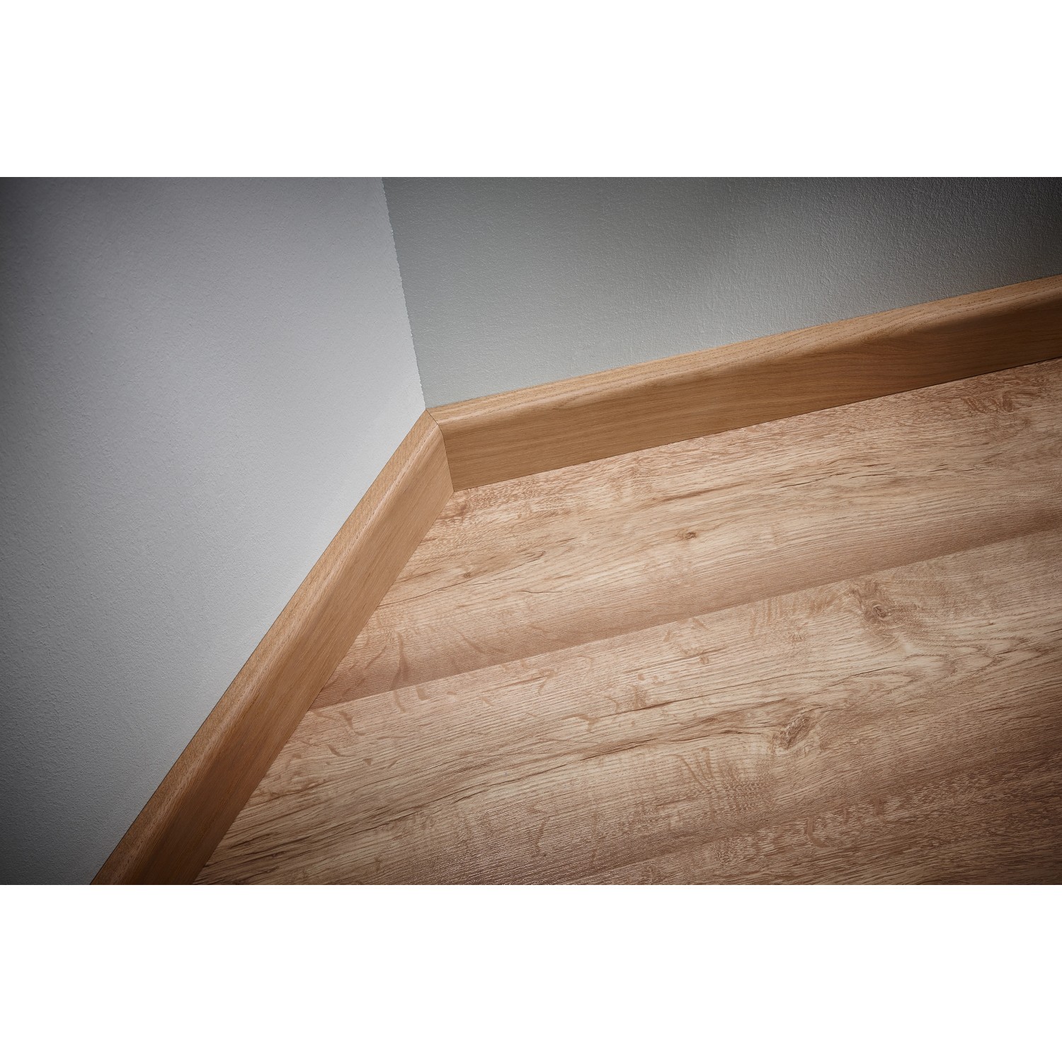 Sockelleiste aus Holz an Wand und Laminatboden, verlegt mit wolfcraft Montage-Set.