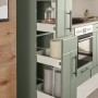 Respekta Landhausküche Anton in Schilfgrün mit offenem Apothekerschrank und Einbaugeräten.