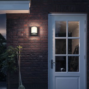 Anthrazitfarbene Philips LED Außenwandleuchte Samondra mit Bewegungssensor an einer Backsteinwand.