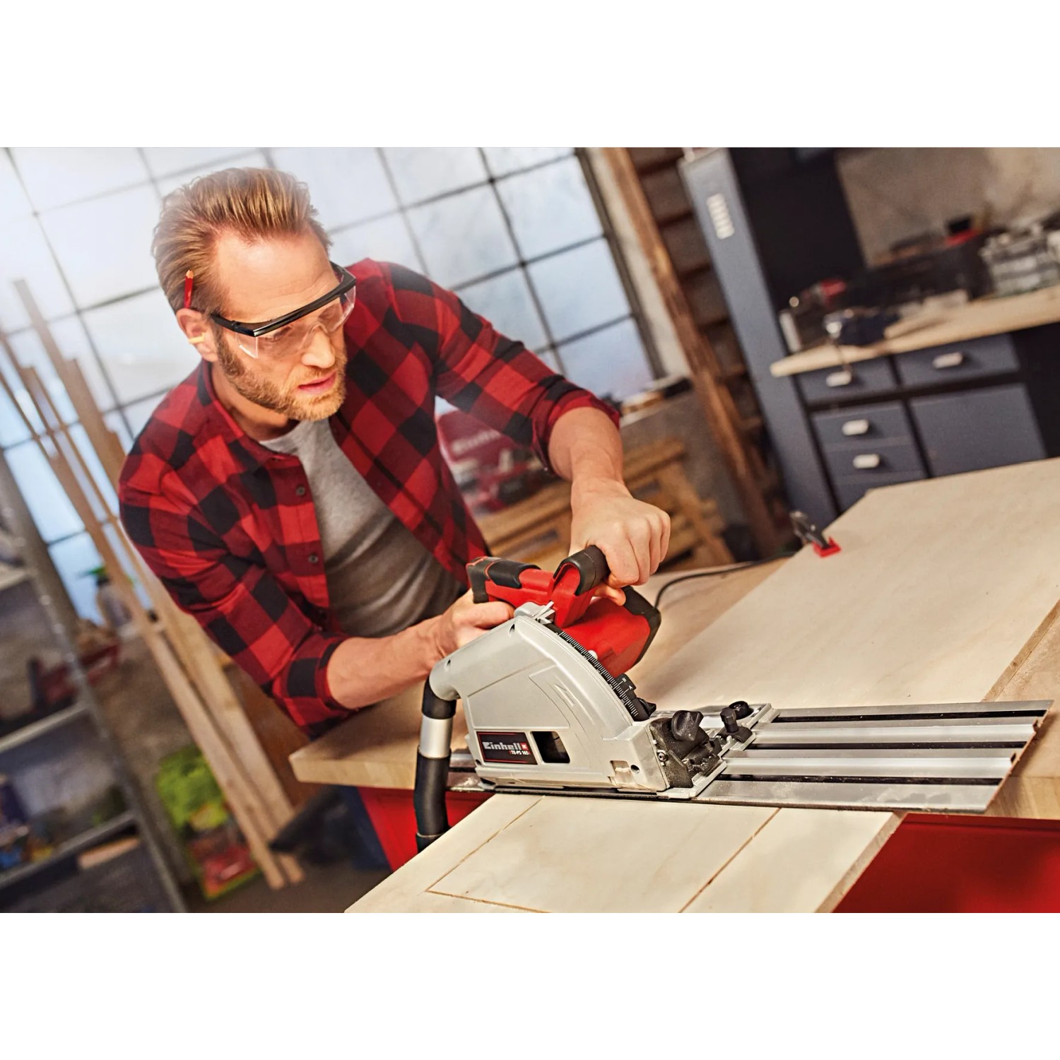 Mann sägt Holz mit der Einhell Tauchsäge TE-PS 165. Handkreissäge für präzise Schnitte.