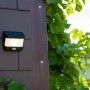 Lutec LED Solar Wandleuchte Try, mattschwarz, mit Bewegungsmelder an Hauswand.
