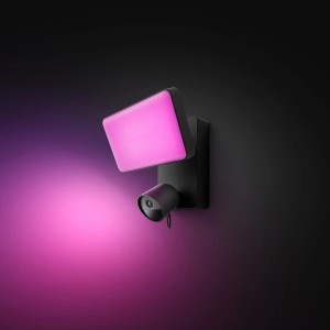 Schwarze Philips Hue Flutlichtkamera Secure mit pinkfarbenem Licht an dunkler Wand.
