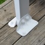 Detailaufnahme der weißen Pfostenbefestigung der Palram Canopia Terrassenüberdachung auf Holzterrasse.