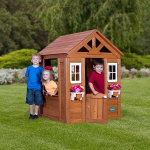 Backyard Spielhaus Timberlake aus Zedernholz mit Kindern, Spielküche und Blumentöpfen.