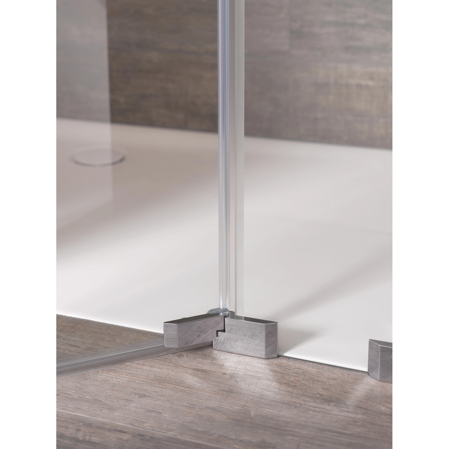 Detailaufnahme: Rahmenlose Dusch-Nischentür Brava mit Chrombeschlägen und transparentem Glas.