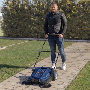 Mann benutzt Einhell Blue Kehrmaschine BT-KM 65 auf einer Terrasse. Die Kehrmaschine ist blau.